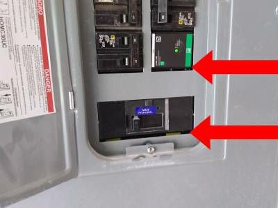 Breakers inside an open electrical panel, with red arrows pointing to gaps beneath the breakers and the main disconnect