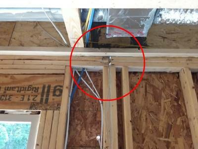 Framing above a door opening, with a red circle around a gap between the two top plates