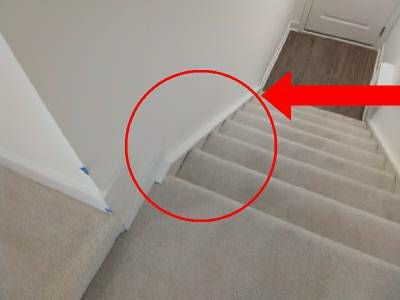 Carpeted stairs seen from above, with a red circle around the gap between the carpet and the white stringer