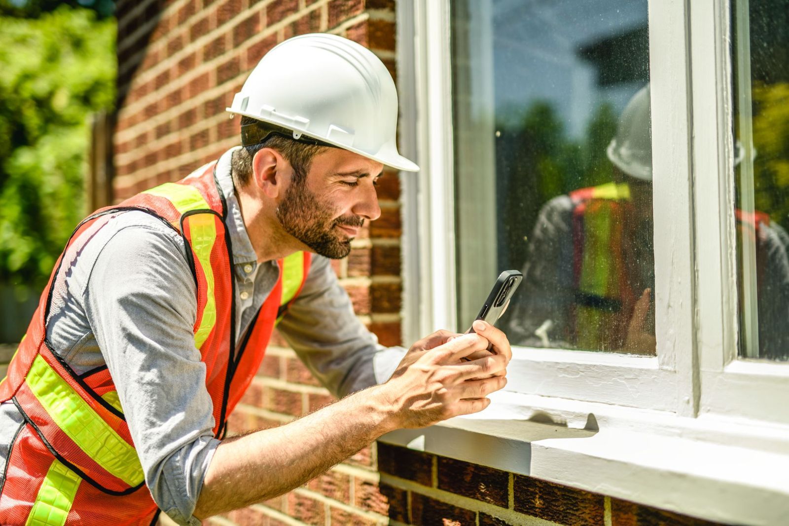 Inspector photographing a window frame to document its condition